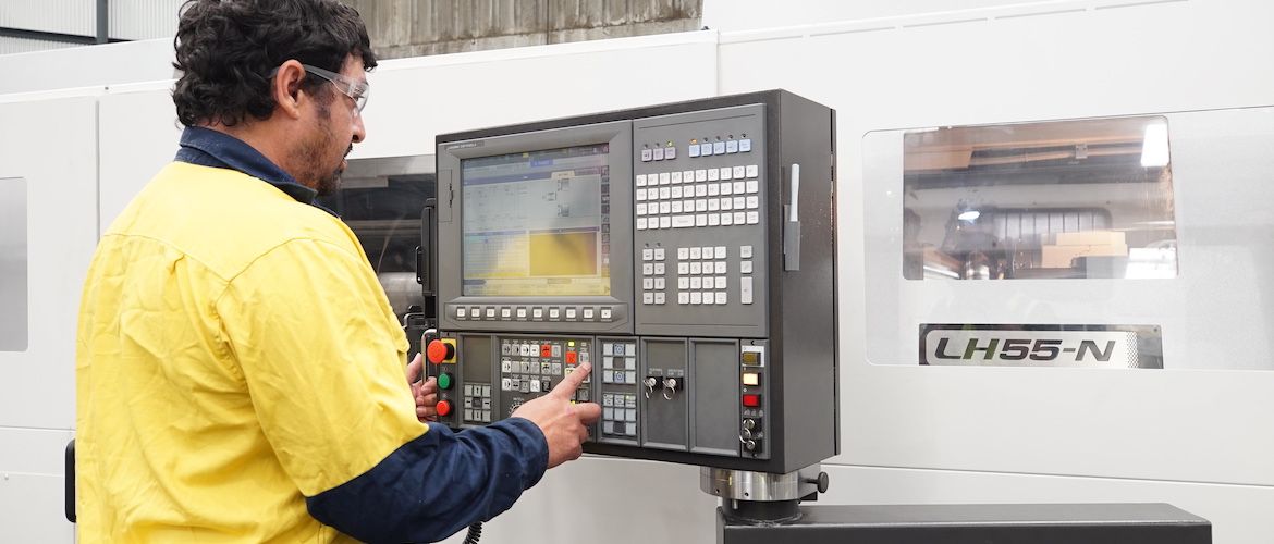 CNC machine operator working with Okuma CNC Lathe Model LH55-N-Cx4000