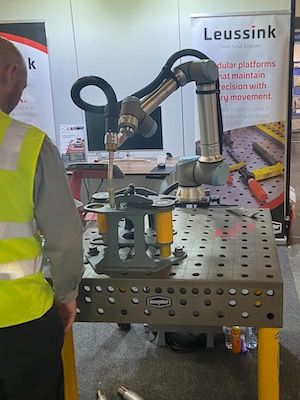 Cobot affixed to Demmeler welding table at AMW tradeshow.