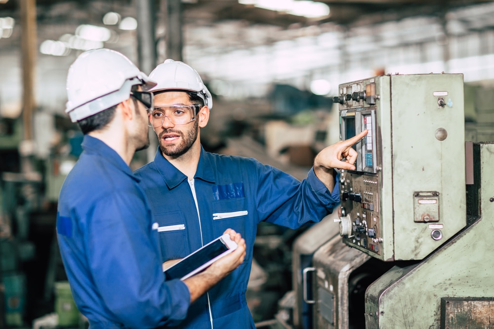 Engineer,teamwork,checking,control,panel,and,teaching,new,worker,to