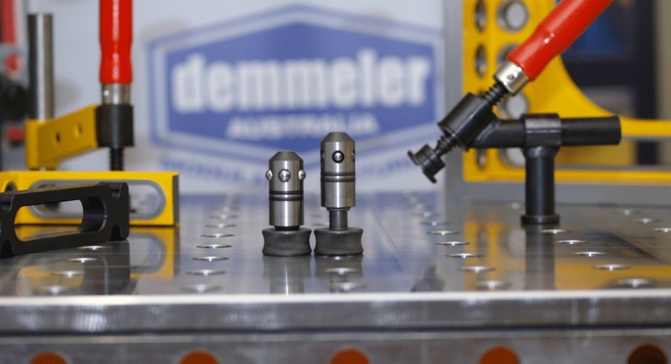 Close-up of Demmeler bolts securing clamps to a 3D modular welding table