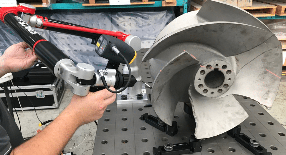 Tomelleri Space Plus 3D measuring arm performing laser scanning on a metal impeller.