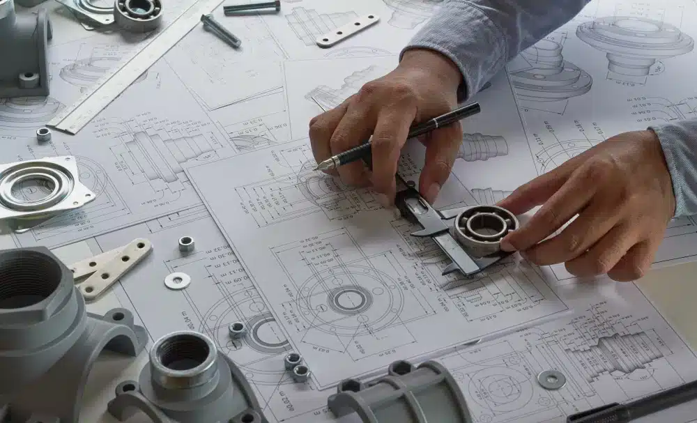 Close-up of mechanical engineering designs being drawn and configured by a specialist technician.
