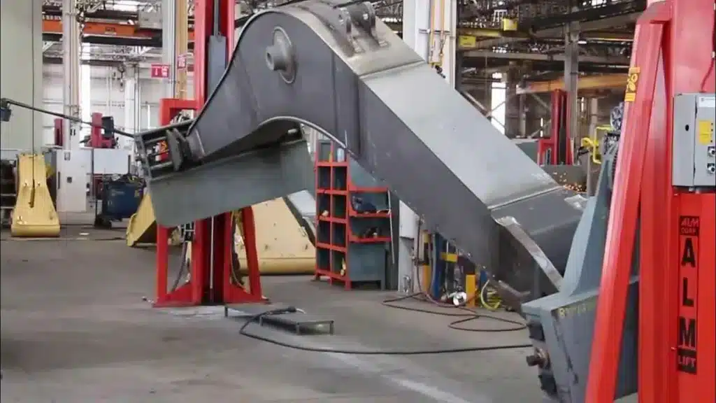 ALM welding positioner tilting a large steel workpiece in a fabrication workshop