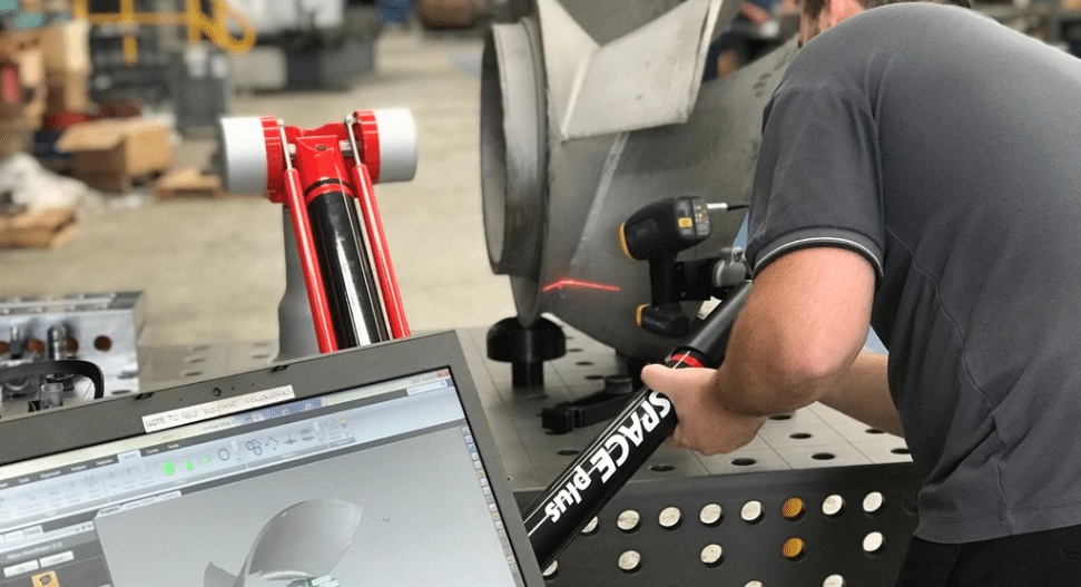 Technician Using A Portable Cmm Arm To Perform Precision Dimensional Inspection On A Large Industrial Component In A Workshop Environment