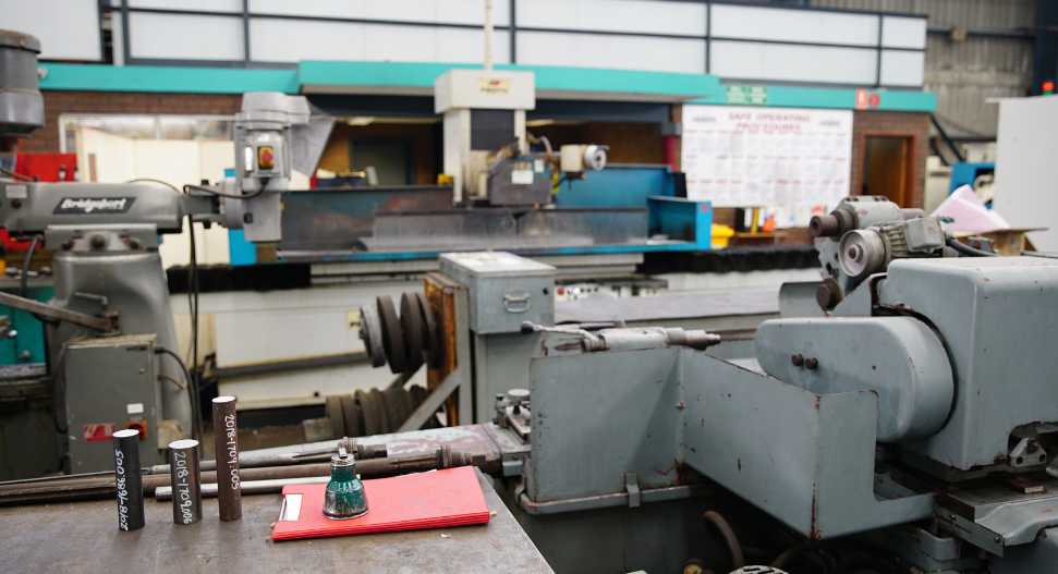 Traditional manual machine shop showing Bridgeport milling machine and engine lathe for conventional machining