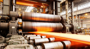 Glowing hot steel sheet passing through heavy rolling mill cylinders in a steel manufacturing plant.