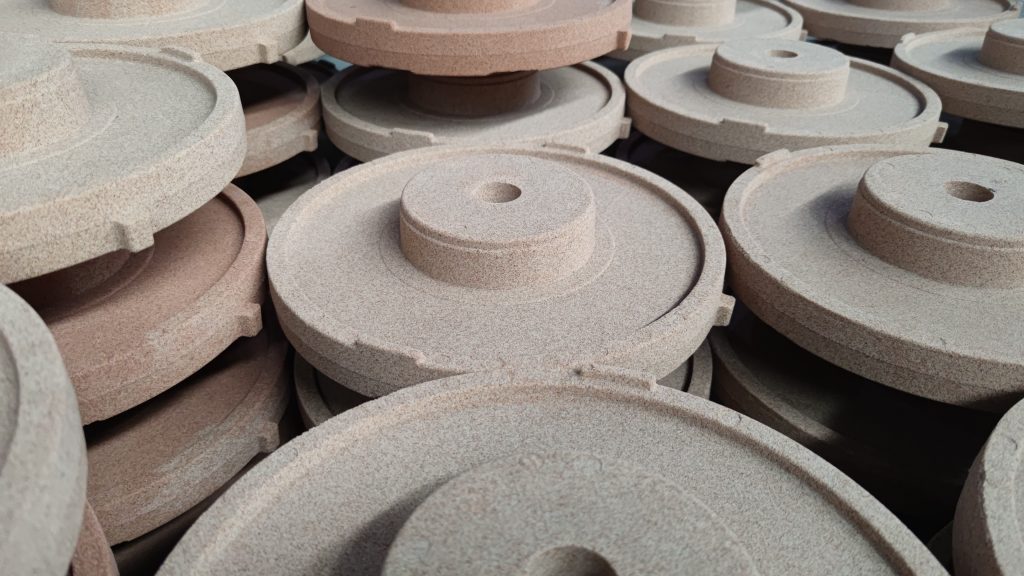 Stacked resin-coated sand shell mold components showing consistent thickness and surface finish from precision coating plant processing.