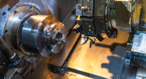 CNC lathe machine close-up showing rotating metal spindle and tool turret with cutting inserts